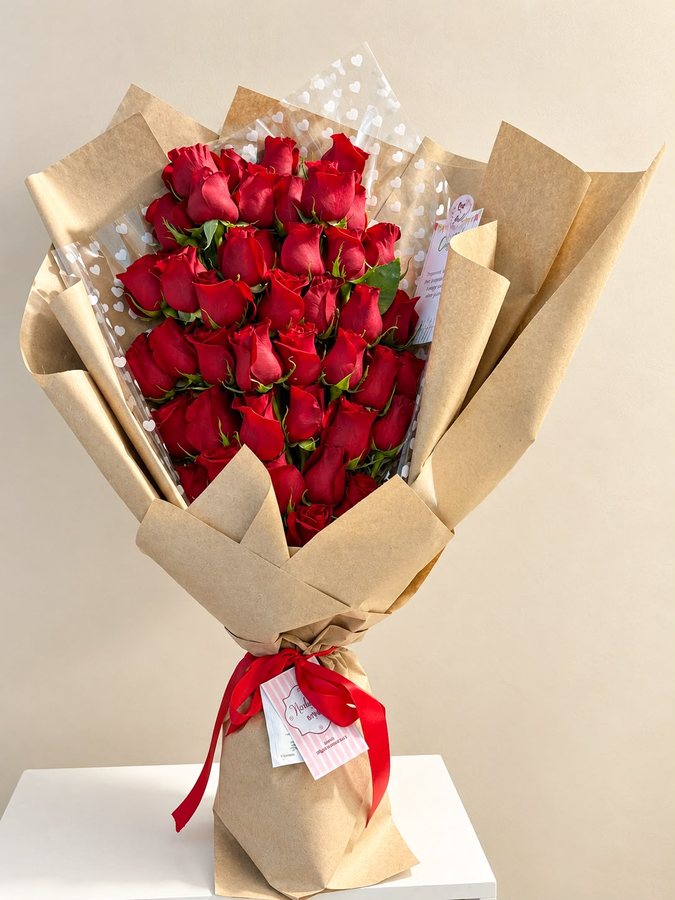 Bouquet Amore Mio 50 rosas rojas en papel kraft con cinta roja en Bogotá